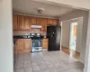 Kitchen with light tile patterned floors, backsplash, and appliances with stainless steel finishes