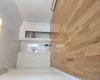 Unfurnished bedroom featuring an AC wall unit, a baseboard radiator, and light wood-type flooring