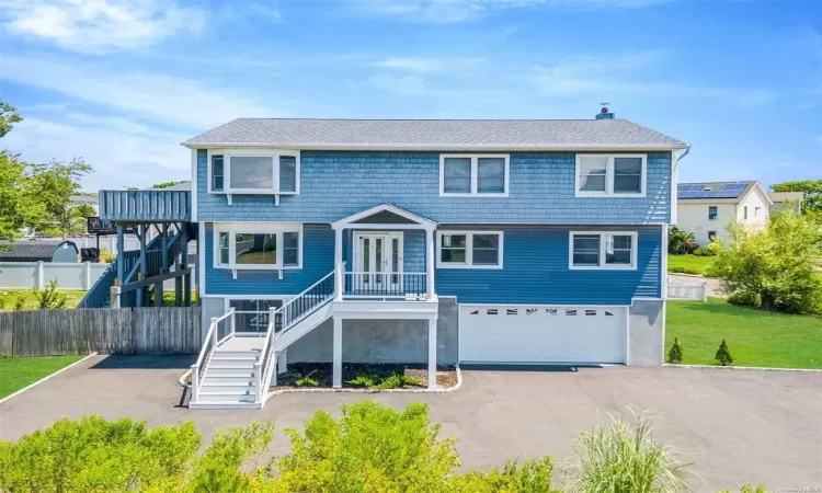 View of front of house featuring a garage and a front lawn