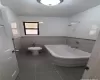 Bathroom featuring tile patterned flooring, toilet, and tile walls