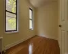 Unfurnished room featuring hardwood / wood-style floors, radiator, and crown molding