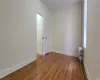 Spare room featuring radiator heating unit, light hardwood / wood-style flooring, and crown molding