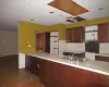 Kitchen with backsplash, dark wood-type flooring, a baseboard heating unit, sink, and kitchen peninsula