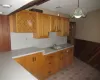 Kitchen with pendant lighting, wood walls, and sink