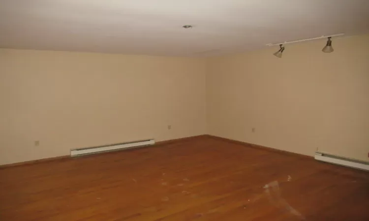 Unfurnished room with hardwood / wood-style flooring and a baseboard radiator