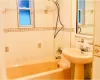 Bathroom featuring tiled shower / bath combo and tile walls