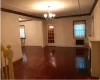 Unfurnished room with dark hardwood / wood-style floors, a notable chandelier, heating unit, crown molding, and a fireplace