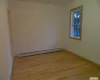 Empty room with light wood-type flooring and a baseboard radiator