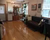 Living room with a wall mounted air conditioner, light hardwood / wood-style flooring, and a notable chandelier