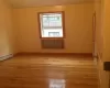 Unfurnished room with baseboard heating and light hardwood / wood-style floors