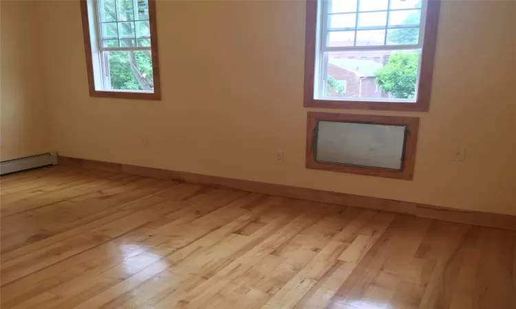 Unfurnished room with light hardwood / wood-style floors and baseboard heating