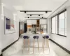 Kitchen featuring a kitchen island with sink, a breakfast bar area, sink, stainless steel appliances, and white cabinets