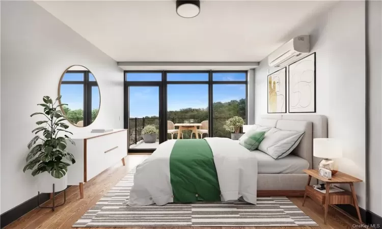 Bedroom with an AC wall unit, multiple windows, and light hardwood / wood-style floors