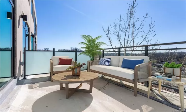 View of patio with a water view, outdoor lounge area, and a balcony