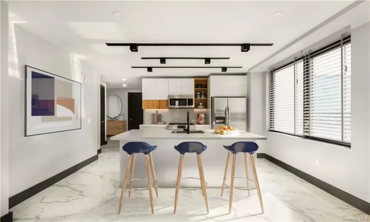 Kitchen with white cabinets, sink, a kitchen island with sink, stainless steel appliances, and a breakfast bar area