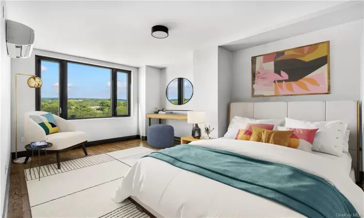 Bedroom featuring a wall mounted AC and light hardwood / wood-style flooring