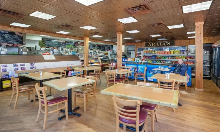 Dining space with a drop ceiling and light hardwood / wood-style floors