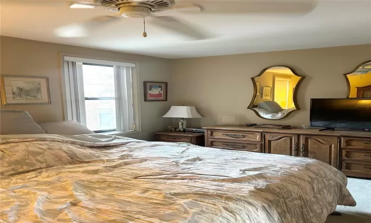 Carpeted bedroom with ceiling fan