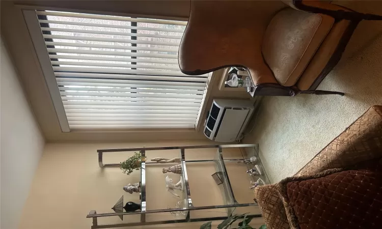 Sitting room featuring a wall unit AC and carpet floors