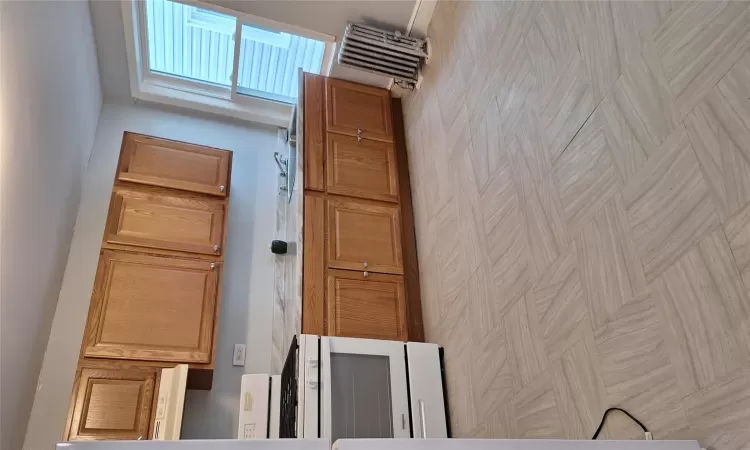 Kitchen featuring sink, stove, exhaust hood, and radiator heating unit