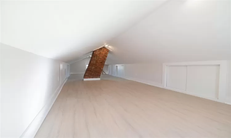 Additional living space with lofted ceiling and light wood-type flooring