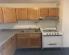 Kitchen with white range oven, sink, and dark tile patterned flooring