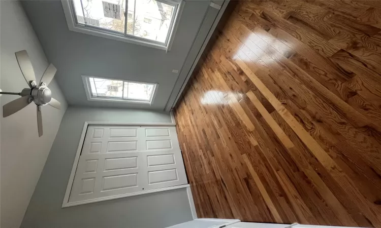 Unfurnished bedroom featuring a closet, hardwood / wood-style flooring, ceiling fan, and a baseboard heating unit