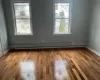 Empty room featuring light hardwood / wood-style floors and a baseboard heating unit