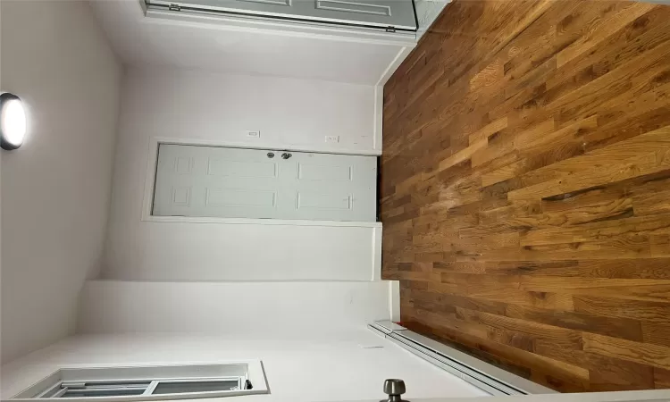 Empty room featuring a baseboard radiator and dark hardwood / wood-style floors