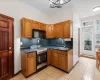 Kitchen with an inviting chandelier, stainless steel range with gas cooktop, sink, decorative backsplash, and light tile patterned floors