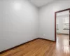 Empty room featuring hardwood / wood-style floors and a baseboard radiator