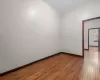 Empty room with a baseboard radiator and dark wood-type flooring