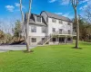 Rear view of property with a deck and a lawn