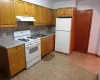 Kitchen featuring decorative backsplash, sink, and white appliances