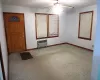 Carpeted foyer entrance with radiator and ceiling fan