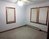 Unfurnished room featuring a baseboard radiator and ceiling fan