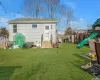 Rear view of house featuring a lawn and a playground