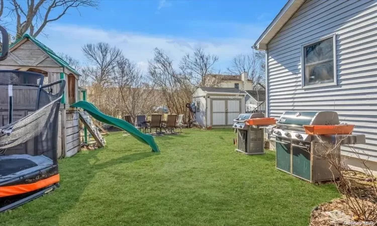 View of yard featuring a storage unit and a trampoline