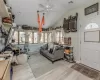 Living room featuring lofted ceiling, ceiling fan, light wood-type flooring, and a electric baseboard heating unit