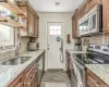 Kitchen featuring light stone counters, stainless steel appliances, and hardwood / wood-style flooring