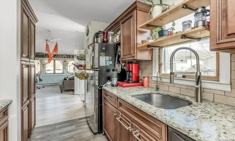 Kitchen with light stone countertops, sink, a healthy amount of sunlight, and light wood-type flooring