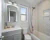 Full bathroom featuring vanity, shower / bathtub combination with curtain, and toilet