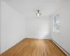 Unfurnished room featuring baseboard heating and light hardwood / wood-style floors