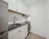 Kitchen featuring light hardwood / wood-style floors, white cabinetry, sink, and appliances with stainless steel finishes