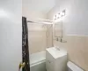 Full bathroom featuring vanity, toilet, tile walls, and bathtub / shower combination