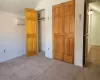 Unfurnished bedroom featuring carpet flooring, a closet, and a wall mounted air conditioner