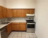 Kitchen with appliances with stainless steel finishes, tasteful backsplash, light tile patterned floors, and sink