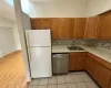 Kitchen featuring sink, stainless steel dishwasher, white refrigerator, backsplash, and light tile patterned floors