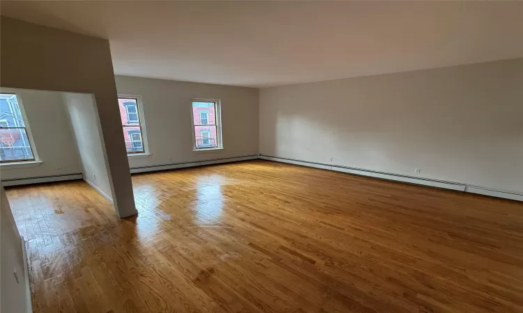 Spare room with a baseboard radiator and light hardwood / wood-style flooring