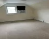 Additional living space featuring carpet, cooling unit, a baseboard radiator, and vaulted ceiling